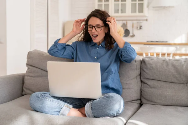 Young happy woman with raised hands looking on laptop screen with lottery victory or job offer email — 图库照片