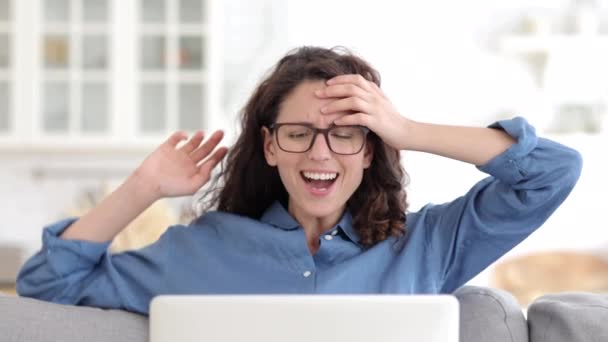 Sorriso de mulher feliz ler boas notícias ou e-mail com oferta de emprego na tela do computador portátil em casa no sofá — Vídeo de Stock