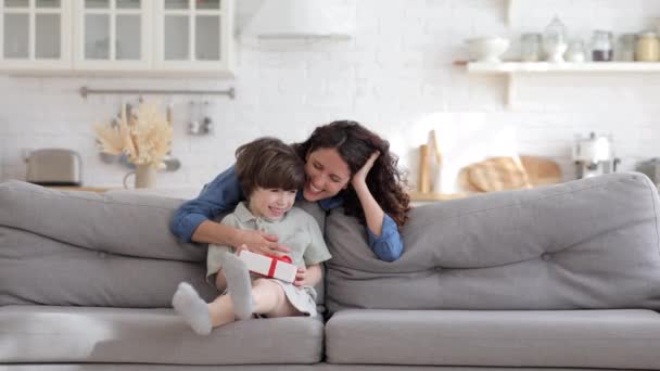 Feliz madre soltera alegre mirando pequeño niño celebrar caja de regalo para el cumpleaños o evento de vacaciones familiares — Vídeos de Stock