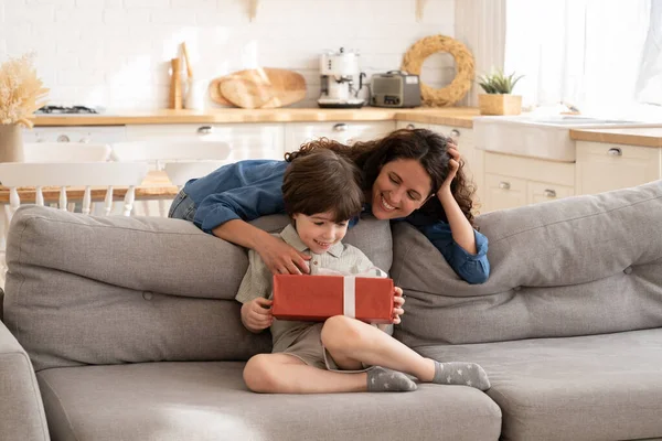 Cadeau d'anniversaire pour enfant : maman attentionnée saluant enfant petit garçon avec boîte cadeau pour événement de vacances — Photo