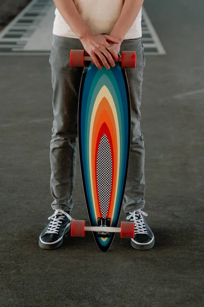 Homem esportivo segurando longboard colorido brilhante. Homem branco hipster skatista com skate — Fotografia de Stock