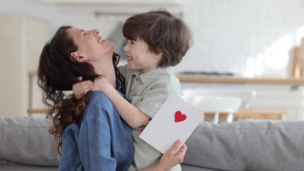 Netter kleiner Sohn gratuliert Mama mit Muttertag Valentinstag oder Geburtstag geben Mutter handgemachte Postkarte — Stockvideo