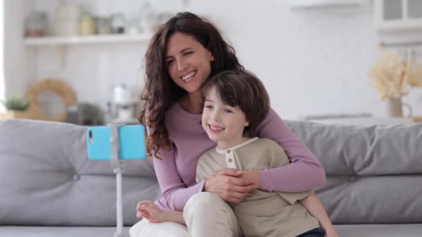 Familj videosamtal: glad mamma och barn av fem våg händer till smartphone säga hej till morföräldrar på nätet — Stockvideo