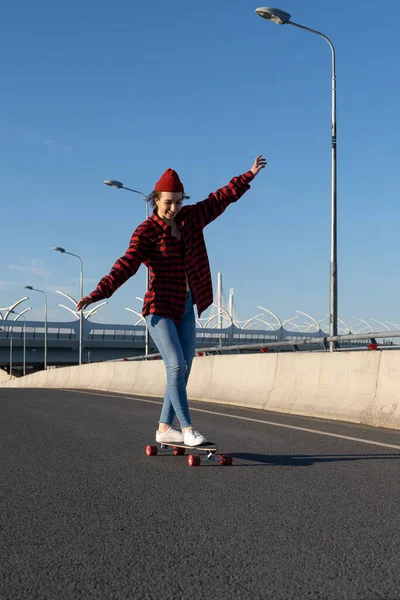 Молода дівчина-гіпстер скейтбординг на міській дорозі щаслива насолоджуватися поїздкою на дошці. Молодіжний та міський спосіб життя — стокове фото
