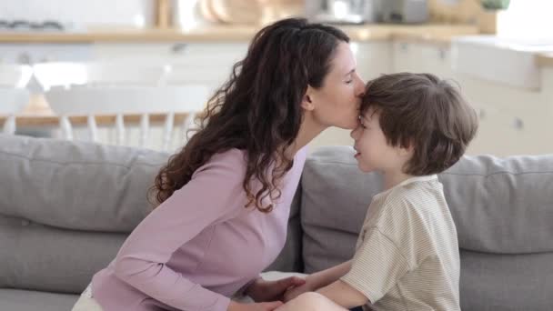 Cute boy kissing hugging mom. Small son greeting mum with women or mother day, birthday embracing — Stockvideo