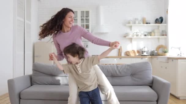 Actieve familie van alleenstaande moeder en leuke kleuter zoon veel plezier thuis dansen op favoriete pop lied — Stockvideo