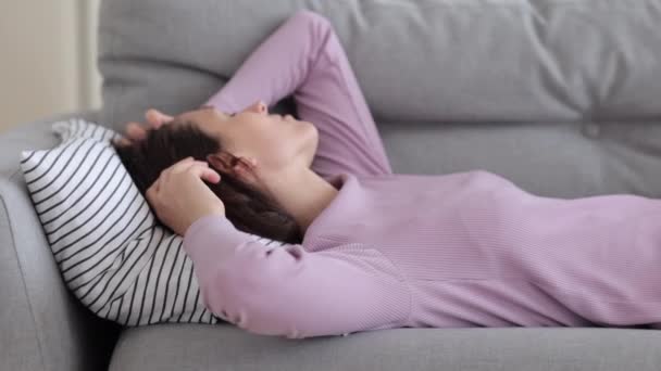 Donna sdraiata sul divano soffrono di dolore, disturbi del sonno o rumore da vicini cercano di rilassarsi riempire male — Video Stock