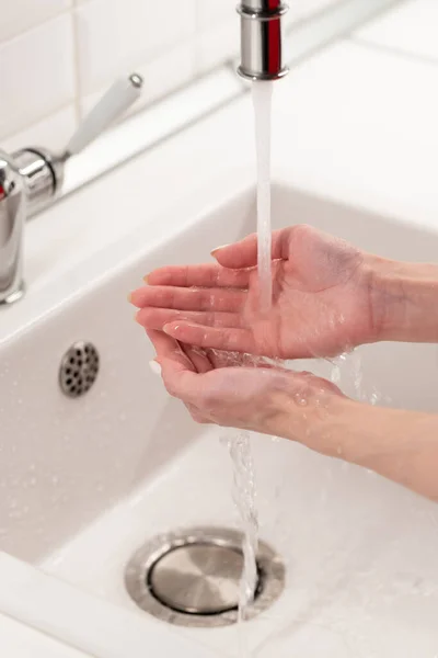 화장실에서 크레인에서 물로 손을 씻는 여자. 청결, 위생 및 건강 개념 — 스톡 사진