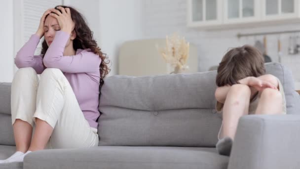 生小孩和生气的母亲分开坐在沙发上，在家庭争吵之后，又紧张又烦躁 — 图库视频影像