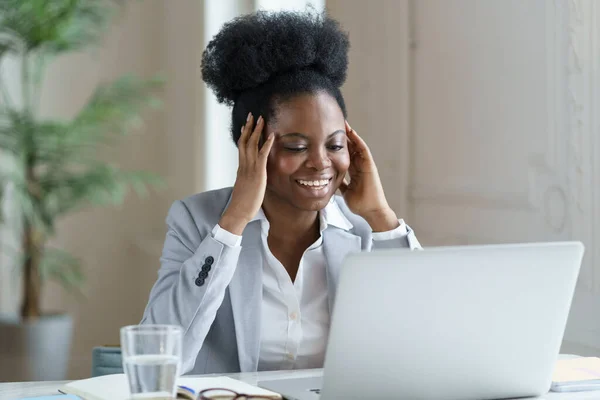 Emocionada mujer de negocios africana leer correo electrónico de noticias positivas con oferta de trabajo en el ordenador portátil con sonrisa feliz — Foto de Stock