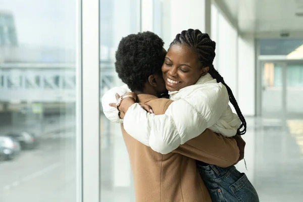 Reunião de casal no aeroporto: Africano feminino conheceu namorado abraço chegando depois de férias ou viagem ao exterior — Fotografia de Stock