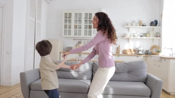 El niño preescolar muy alegre baila junto con su madre activa. Mamá padre e hijo disfrutan de la actividad de ocio — Vídeos de Stock