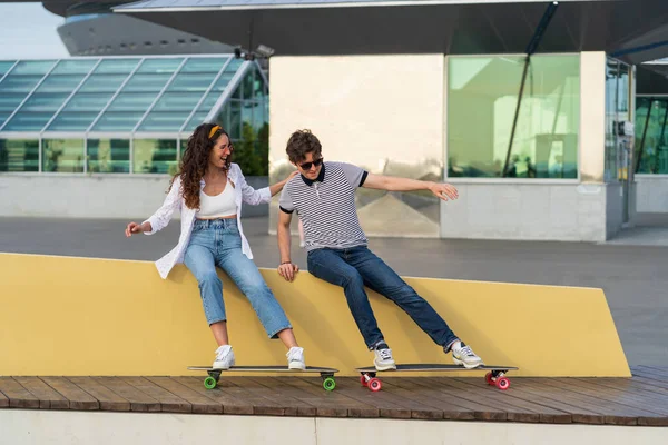Безтурботний хіпстер чоловік і жінка молода пара розважаються після скейтбордингу сміються насолоджуватися часом разом — стокове фото