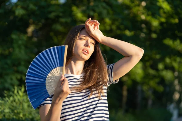 Mujer joven sufre un golpe de calor al aire libre. Chica infeliz se siente mal de la frente de tacto de temperatura caliente — Foto de Stock