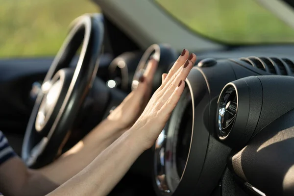 Kobieta ręka kierowcy w chłodzeniu cios powietrza z sieci klimatyzatora w samochodzie. Ciepło i chłodnica samochodowa — Zdjęcie stockowe