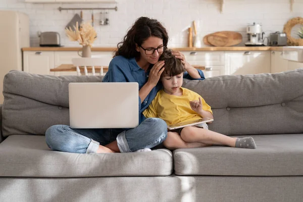 Jeune mère célibataire travail indépendant de la maison et aider les petits enfants avec l'école à la maison et l'éducation en ligne — Photo