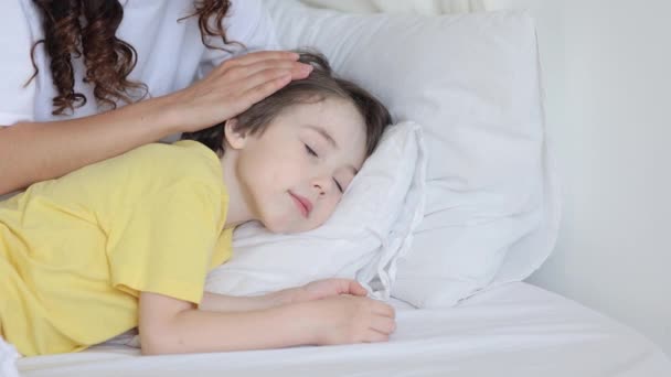 Amore mamma controllare bambino fronte temperatura accarezzamento e ictus bambino dormire in comodo letto — Video Stock
