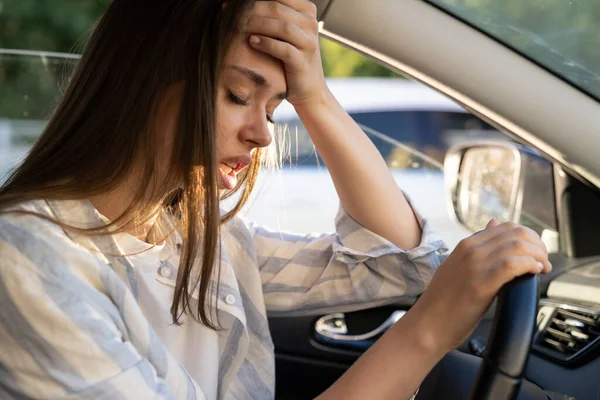 Tired young woman car driver suffer from headache or migraine pain inside vehicle touch forehead — Stock Photo, Image