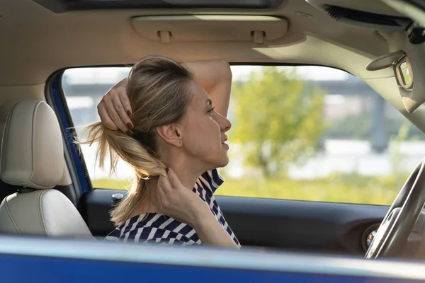 Gelangweilte Autofahrerinnen im Spiegelspiel mit Haaren im Stau. Autofahrerin lenkt von Straße ab — Stockfoto