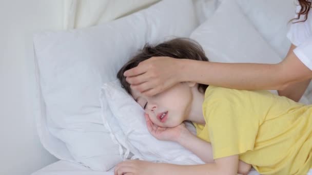 Caring madre mano accarezzare il figlio come calmo rilassato bambino dormire a letto su morbido cuscino sotto coperta — Video Stock