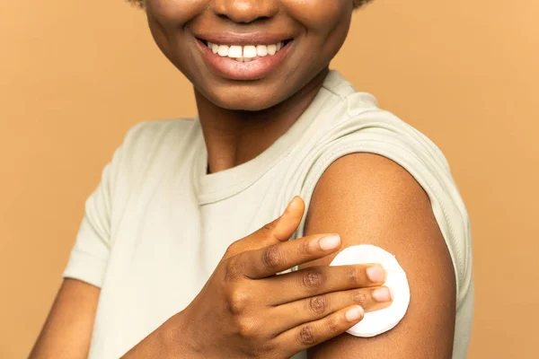Вакцинація щасливої африканської жінки, що демонструє руку з ватною щіткою після ін'єкції вакцини. вакцинація . — стокове фото