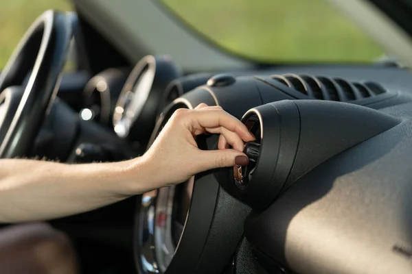 Mulher ligue o ar condicionado no carro no sistema de refrigeração da grade do painel do veículo. Condicionamento de automóveis — Fotografia de Stock
