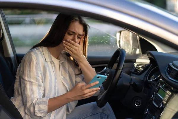 Weinendes junges Mädchen las Nachricht im Handy. Frustriert verärgert junge Frau am Fahrersitz im Auto — Stockfoto