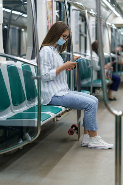 Milenyum kadın yolcusu metroda covid-19 'a karşı cep telefonu maskesi takıyor.. — Stok fotoğraf