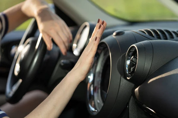女性の手は車のエアコンパネルをチェックします。調整システムで手を握っている女性ドライバー — ストック写真