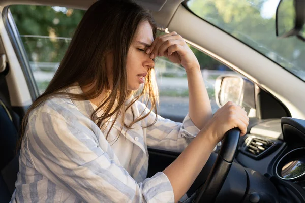 Tired young woman car driver suffer from headache or migraine pain inside vehicle touch forehead — Stock Photo, Image