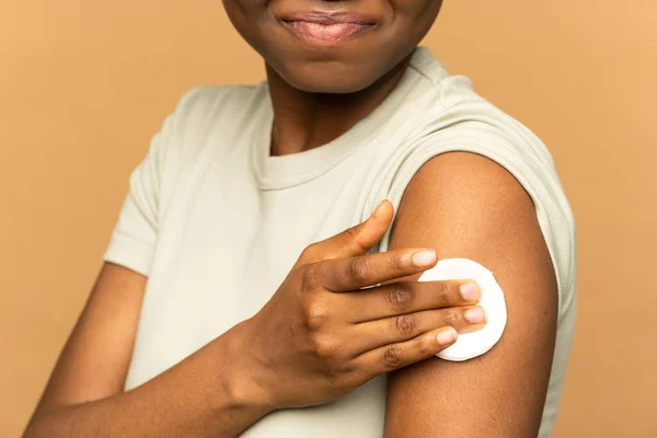 Вакцинація африканської жінки, що демонструє руку з ватною щіткою після ін'єкції болючої вакцини від гепатиту — стокове фото