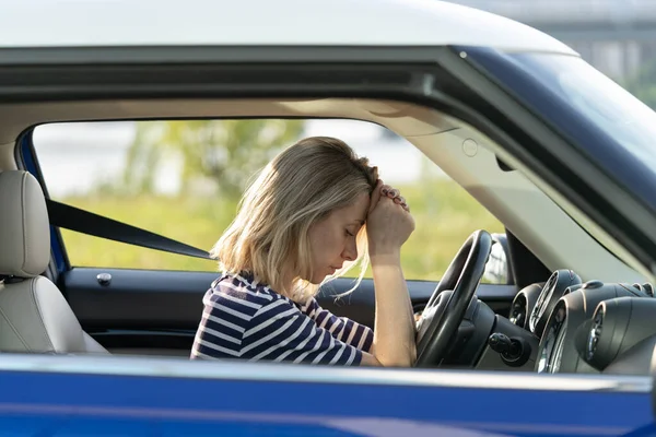 Mujer frustrada en coche acostada en el volante cansada con los ojos cerrados. Mujer agotada de problemas — Foto de Stock