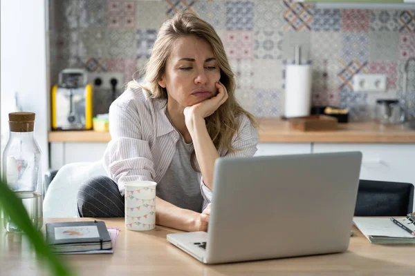 Unzufriedene Frau mittleren Alters sucht während Covid-19-Quarantäne auf Laptop nach einem neuen Job — Stockfoto
