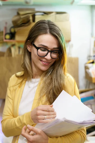 Piccola impresa o e-retail negozio proprietario donna controllare i documenti per ordine del cliente di consegna in magazzino — Foto Stock