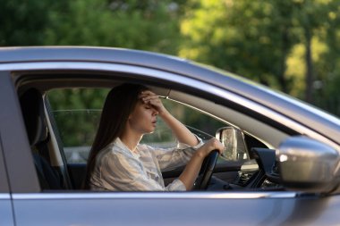 Baş ağrısı çeken arabası olan stresli bir kız. Hüsrana uğramış genç bayan sürücü hastalıktan muzdarip.