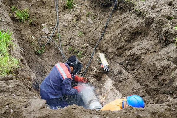 Robotnik naprawia zepsutą rurę wodociągową. Koncepcja naprawy rur kanalizacyjnych. — Zdjęcie stockowe