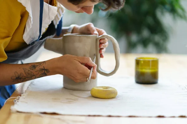 Creating ceramic tableware in pottery workshop studio: concentrated artist girl work on handmade jug — Stock Photo, Image