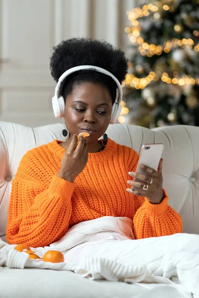 Noël et Nouvel An à la maison : femme africaine se détendre du travail pendant les vacances d'hiver assis sur le canapé — Photo