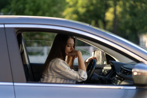 Пьяная девушка за рулем машины. Несчастная уставшая молодая женщина в автомобиле, страдающая от головной боли или передачи — стоковое фото