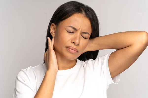 Niña africana cansada sufre de dolor de cuello, problemas de columna vertebral, postura incorrecta, fibromialgia. Dolor de cuello —  Fotos de Stock