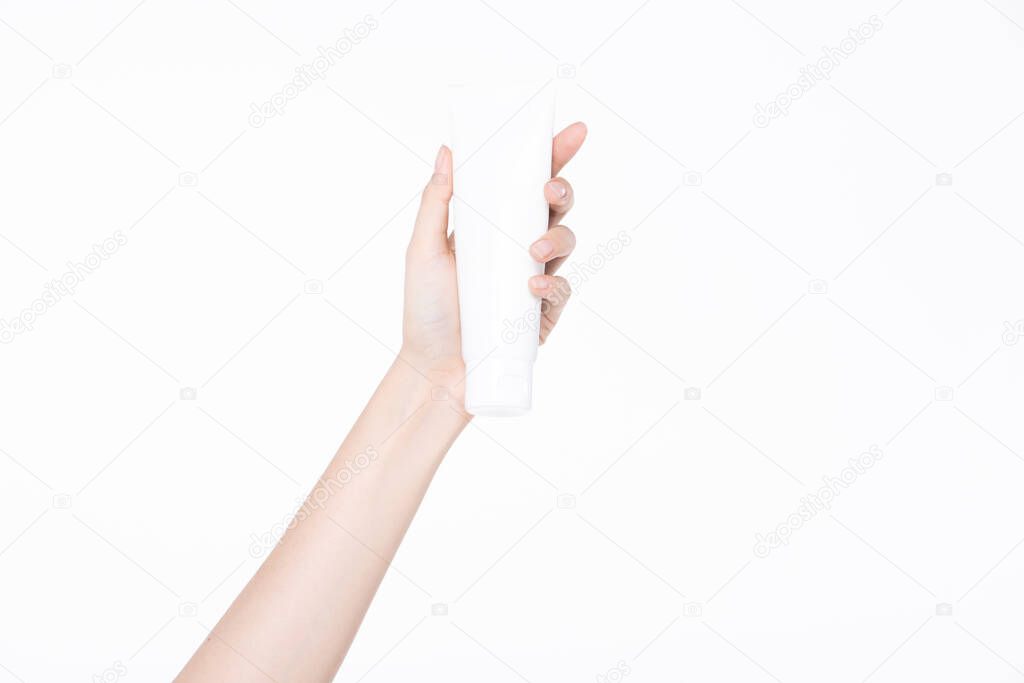 Female beautiful talent hand, arm and fingers in good shape figure hold empty cosmetic tube product to show, studio lighting isolated white background for advertising body part