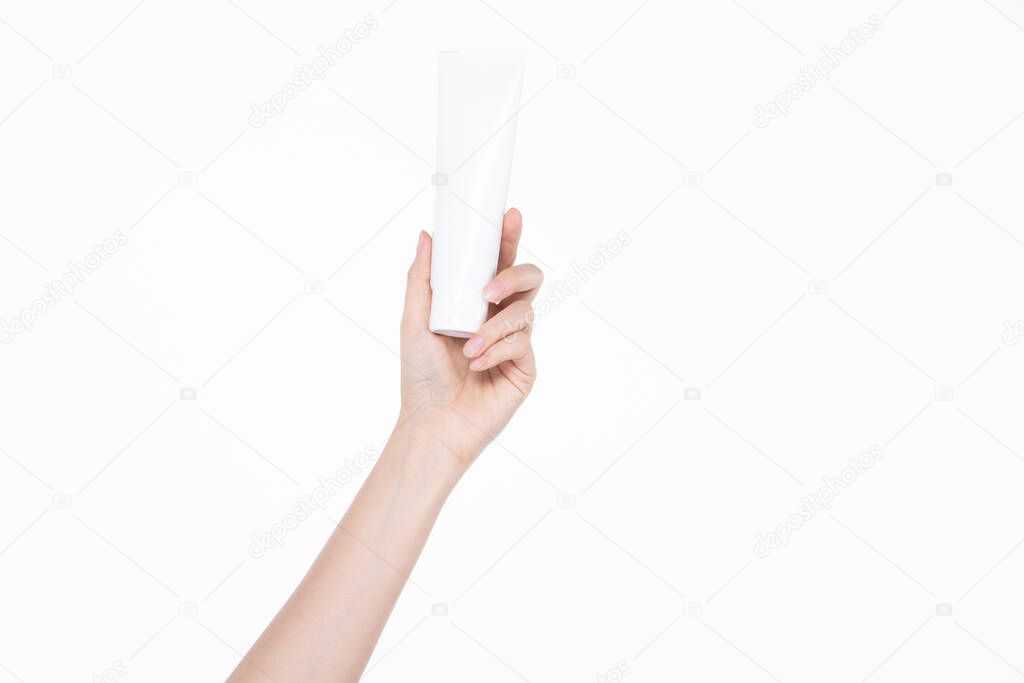 Female beautiful talent hand, arm and fingers in good shape figure hold empty cosmetic tube product to show, studio lighting isolated white background for advertising body part