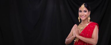 Hint güzel gözleri, mükemmel makyaj gelini, geleneksel etnik Pakistanlı gelinlik giymiş güzel bir kadının portresi, ağır mücevherler, siyah perde arkası afişi, fotokopi alanı.