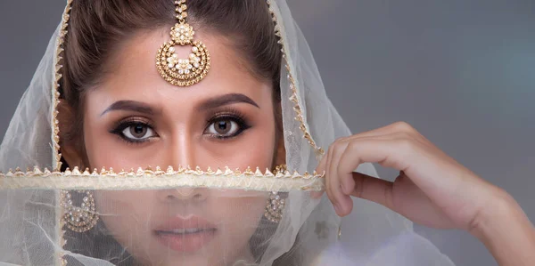 完璧な結婚式の花嫁を構成するインドの美しさの目 重いジュエリーと伝統的な民族パキスタンのブライダル衣装で美しい女性の肖像画 グレーの背景コピースペース — ストック写真