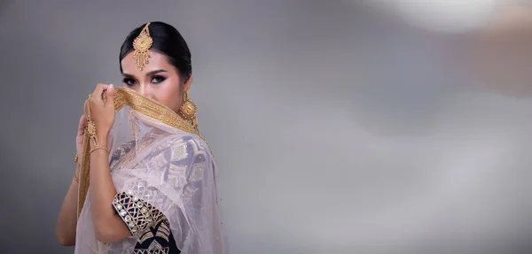 完璧な結婚式の花嫁を構成するインドの美しさの目 重いジュエリーと伝統的な民族パキスタンのブライダル衣装で美しい女性の肖像画 グレーの背景バナーコピースペース — ストック写真