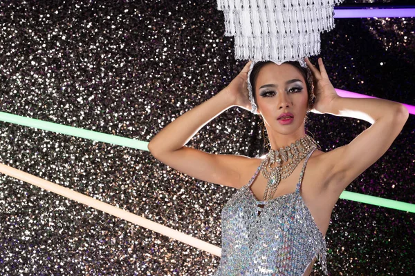 Half body portrait of Asian Transgender Woman in Cabaret Carnival Fancy mirror reflect silver Dress Gown head set over Dark background as profile shooting copy space