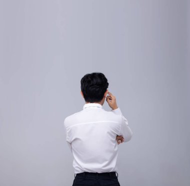 Ofis Adamı beyaz gömleği geri dönüp kafasından ve ellerinden hislerini ifade ediyor. Gri arka planda büyük boş kopya alanı var.