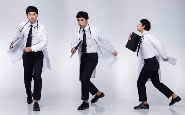 Full length body of Asian Male Doctor in white labcoat uniform with stethoscope and run to case, Medical hospital, gray background isolated copy space