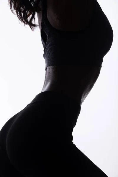 若いフィットネスのシルエットボディスリムでアスリートの筋肉を背部に持っている素敵な体を持っている女性 コントラストの高い白い背景コピースペース — ストック写真