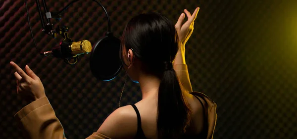 アジアのティーンエイジャーの女性の黒い髪のヘッドフォンは マイクコンデンサ 作曲ハンギング以上の歌を大声でパワーサウンドを歌います スタジオ防音壁部屋コピースペースを吸収 — ストック写真